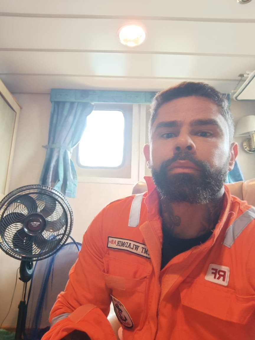 CME Wladmir, marítimo brasileiro, com macacão laranja de trabalho em navio de apoio offshore